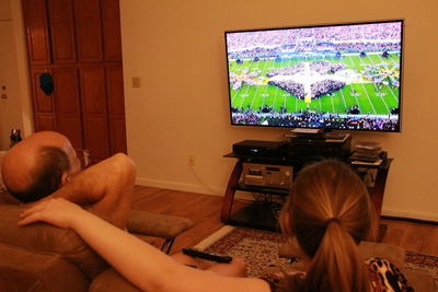 Rear view of man relaxing at home