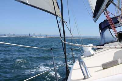 Sailboats sailing on sea against clear sky