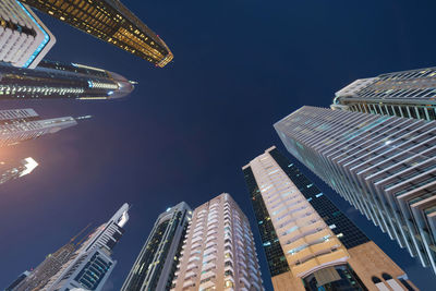 Low angle view of modern buildings against sky at night