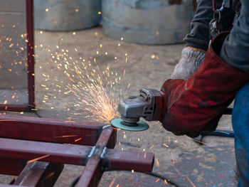 Close-up of person using machinery at workshop