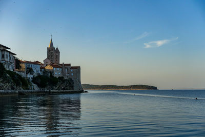 Scenic view of sea by buildings against sky