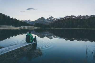 Reflection of man in lake against sky