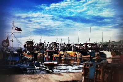 View of harbor against cloudy sky