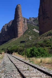 Railroad track amidst rocks against clear sky