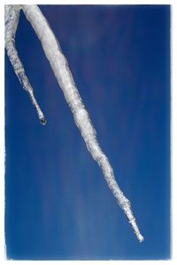 Close-up of snow against clear blue sky