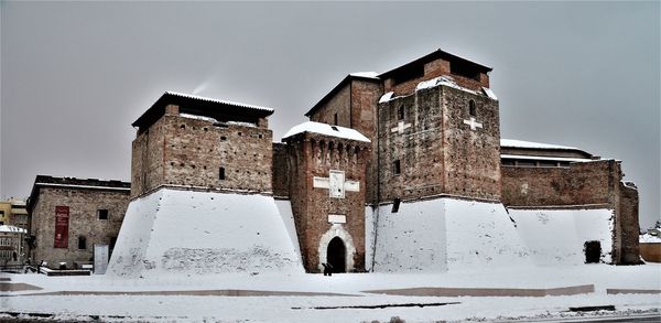 Low angle view of old building against sky during winter