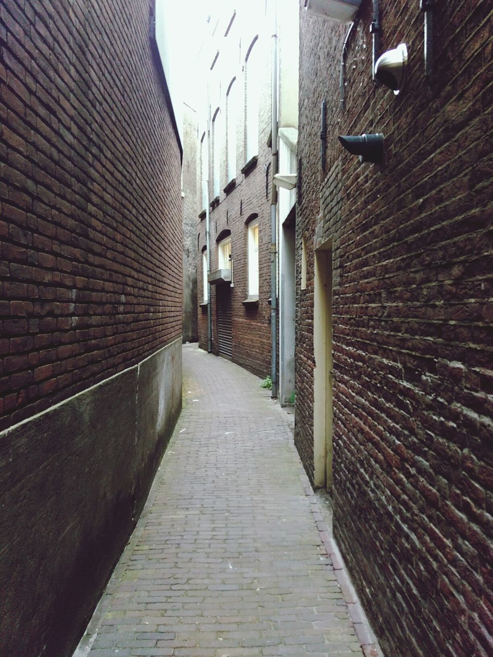 architecture, building exterior, built structure, the way forward, cobblestone, diminishing perspective, narrow, alley, walkway, house, residential structure, vanishing point, brick wall, street, building, residential building, pathway, footpath, long, wall - building feature