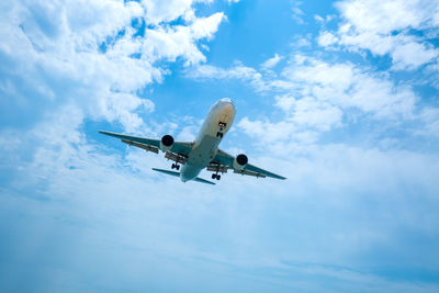 Low angle view of airplane flying against sky