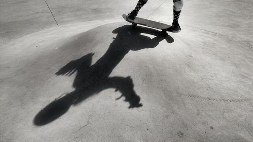 Low section of person skateboarding by shadow at park