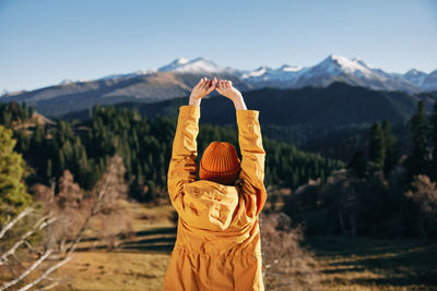 Rear view of woman standing against mountain