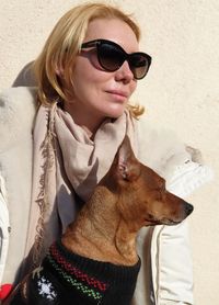 Close-up of woman wearing sunglasses with dog standing outdoors