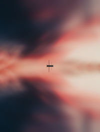 Airplane flying against sky during sunset