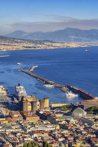 High angle view of city by sea against sky