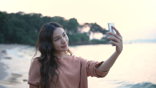 Portrait of young woman using mobile phone