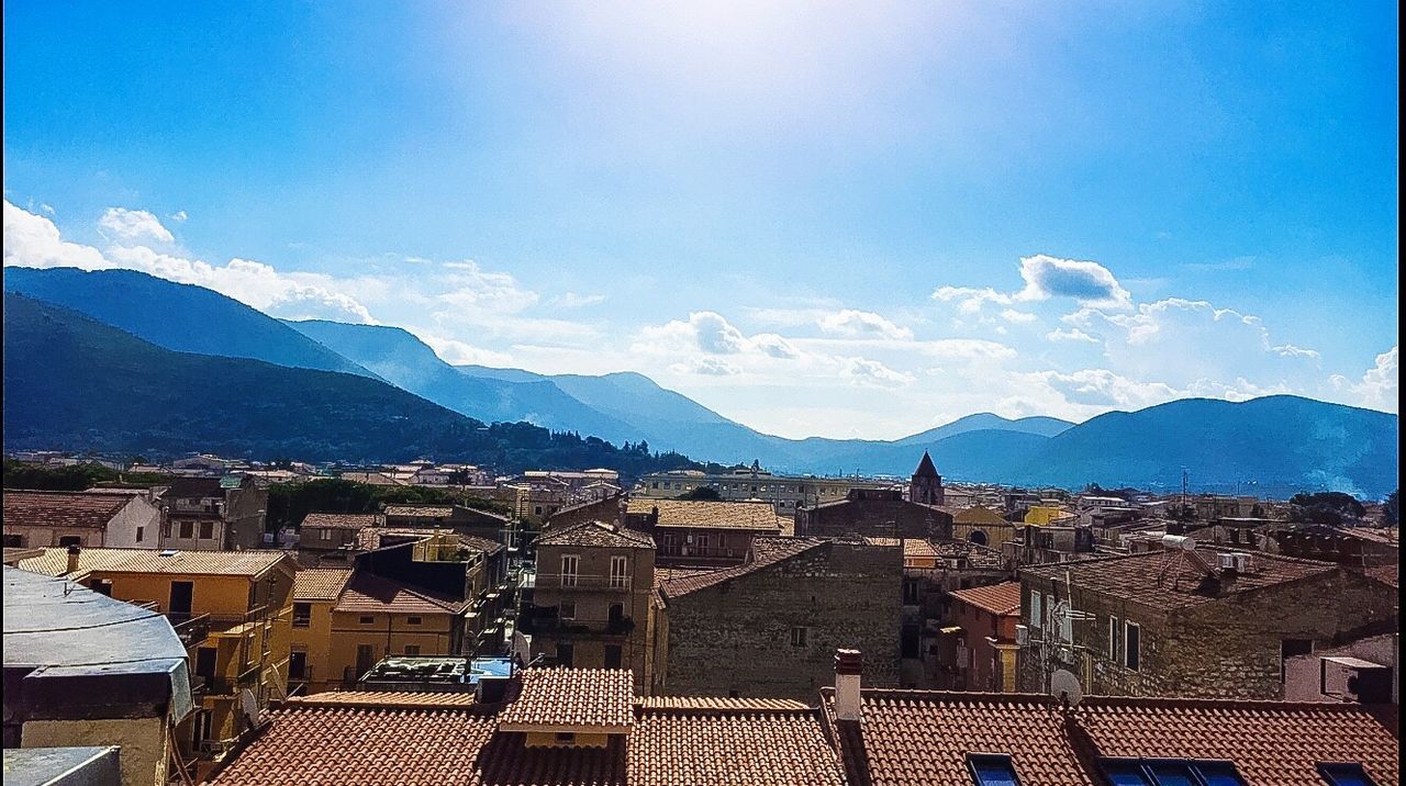 building exterior, architecture, built structure, mountain, cityscape, mountain range, residential district, city, residential structure, sky, residential building, crowded, town, house, blue, townscape, high angle view, roof, day, cloud