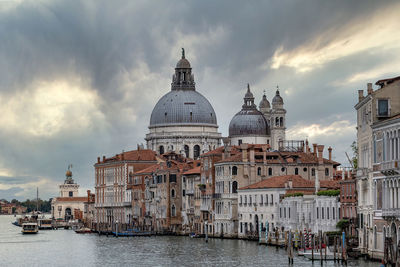 View of buildings in city against cloudy sky