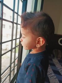Portrait of boy looking through window