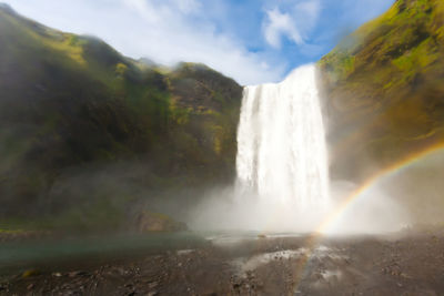 Scenic view of waterfall against sky