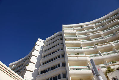 Low angle view of modern building against clear blue sky