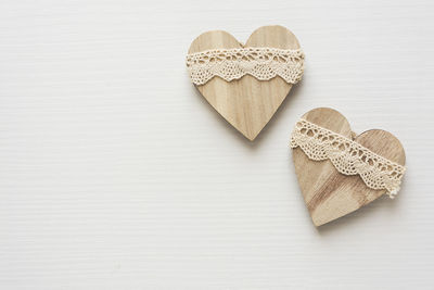 Close-up of wooden heart shape with lace on table
