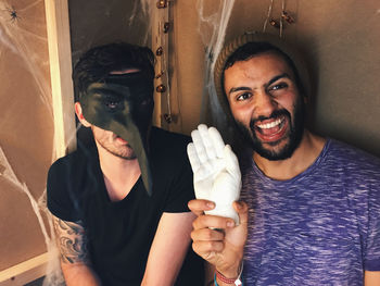 High angle view of men gesturing while sitting against wall during halloween