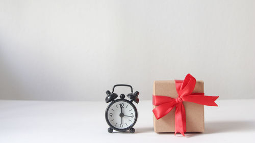 Close-up of alarm clock on table against wall