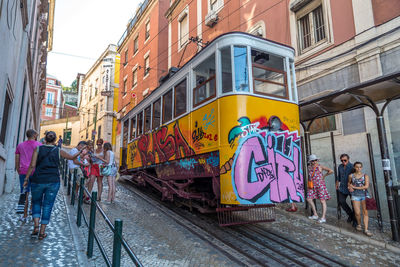 People on railroad tracks amidst buildings in city