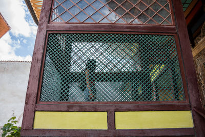 Low angle view of young woman standing in bakhchisaray palace seen through window