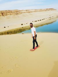 Full length portrait of man sandboarding in egypt