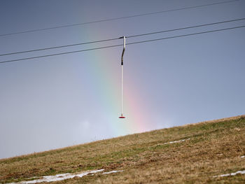 One anchor on the ski lift with a rainbow on the background