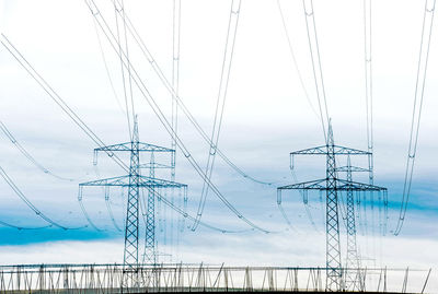 Low angle view of electricity pylon against sky