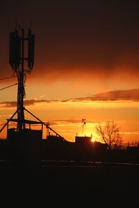 Silhouette electricity pylon against sky during sunset