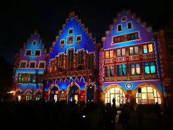 People in illuminated building at night