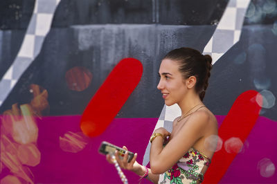 Side view of young woman using mobile phone