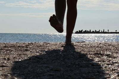 Low section of person standing on beach