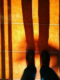 Low section of man standing on tiled floor