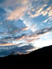 Low angle view of silhouette mountain against dramatic sky