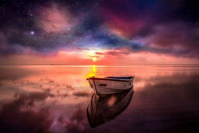 Boat moored on sea against sky during sunset