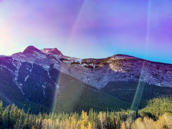 Scenic view of rainbow over mountains against sky