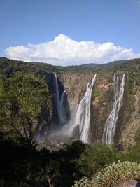 Scenic view of waterfall against sky