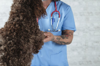 Rear view of woman standing against wall