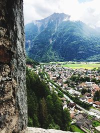 Aerial view of townscape by mountain against sky