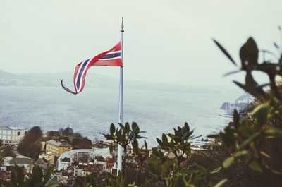 Flag in city against sky