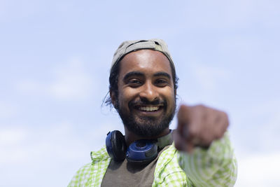 Portrait of smiling young man against sky