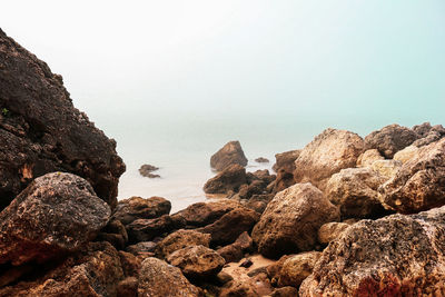 Rocks on beach against clear sky