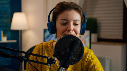 Smiling woman podcasting at home