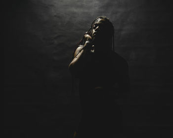 Rear view of woman standing against wall