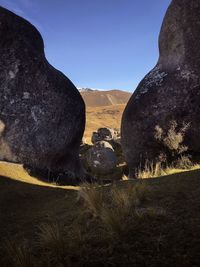 Rock formations on field against sky