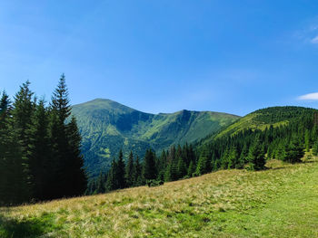 Scenic view of mountains against blue sky