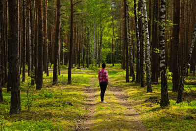 Woman running on footpath in forest